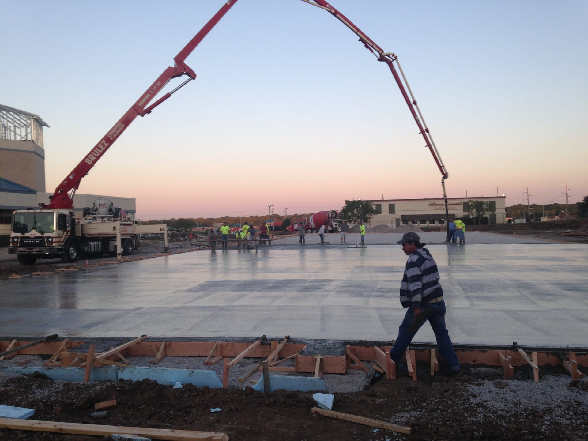 Concrete pump truck pouring a large commercial slab
