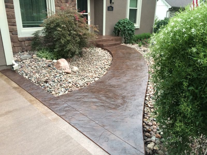 Stamped concrete walkway with a river-rock border