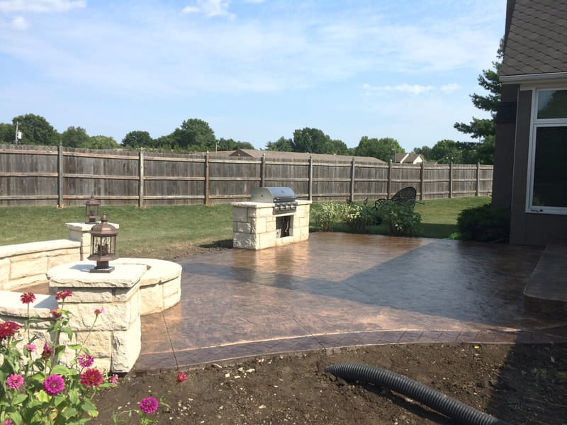 Stamped concrete patio with a stone water and fire feature