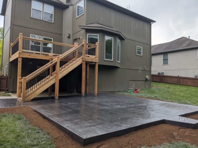 Charcoal stamped concrete patio behind a home